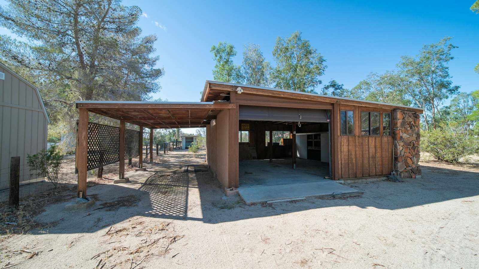 A timber carport beside a timber garage