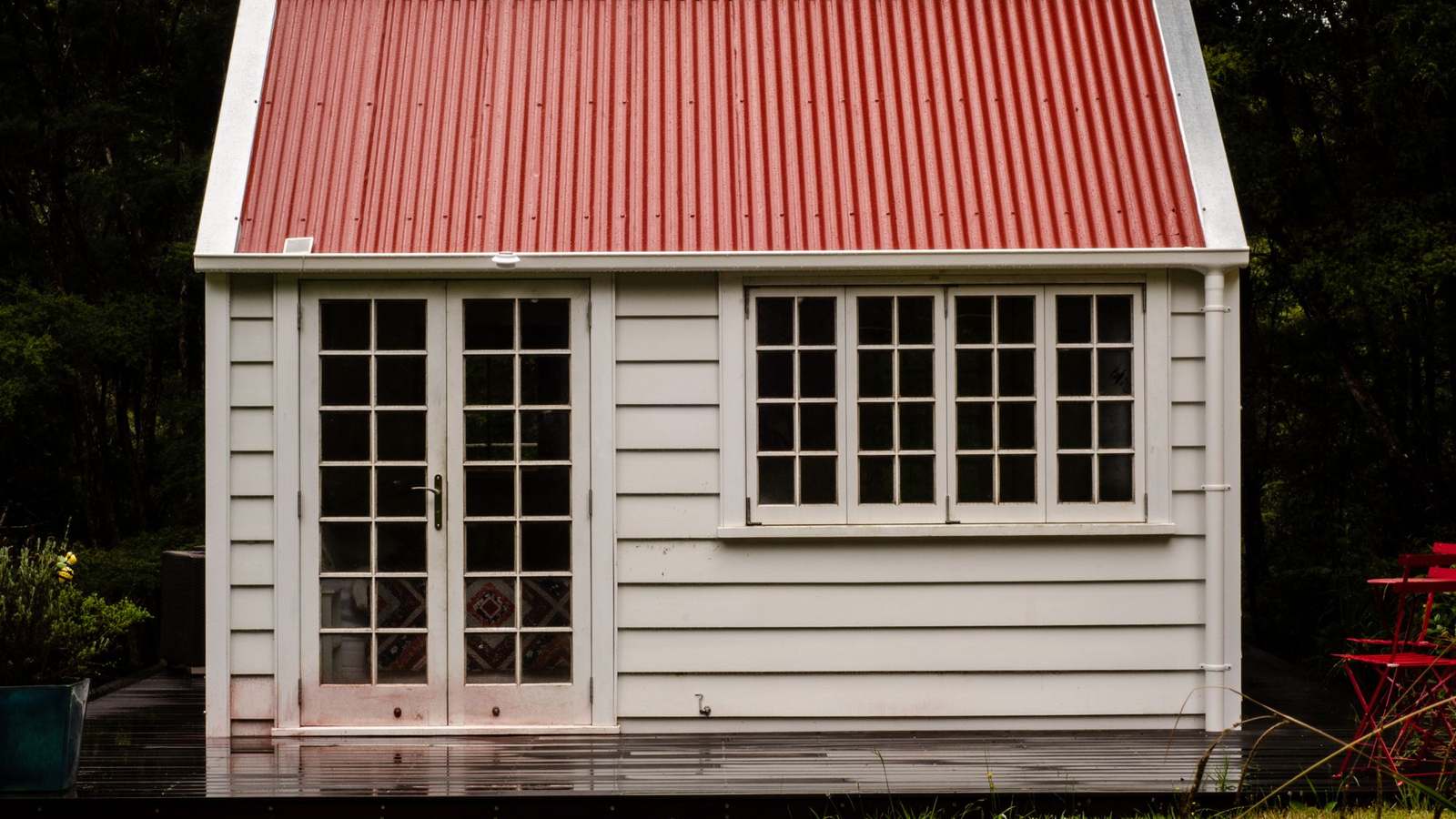 A small white weatherboard cottage with a red iron roof in Northland