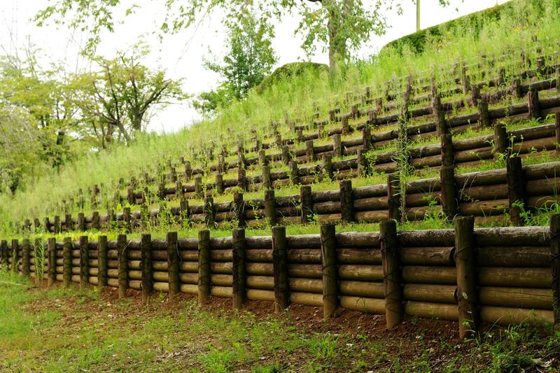 Terraced timber retaining walls stepping up a grassy slope