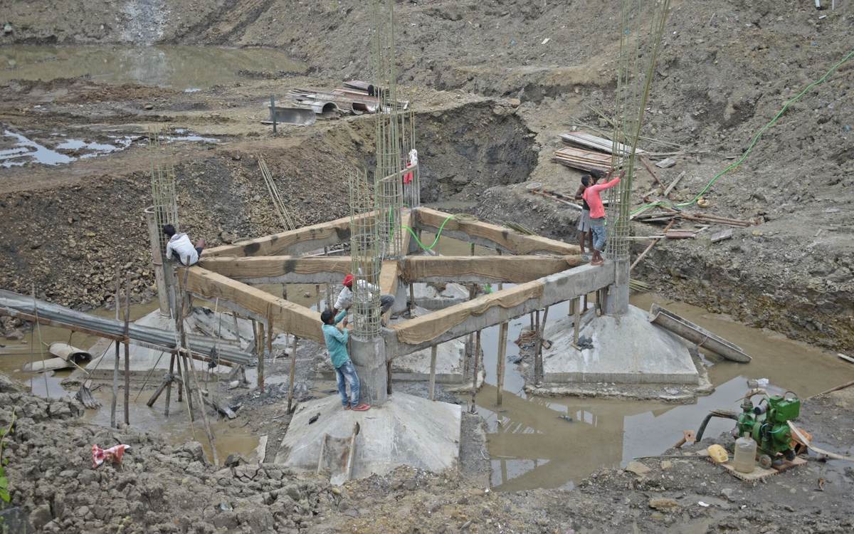 Concrete footings being formed on a flooded, muddy building site